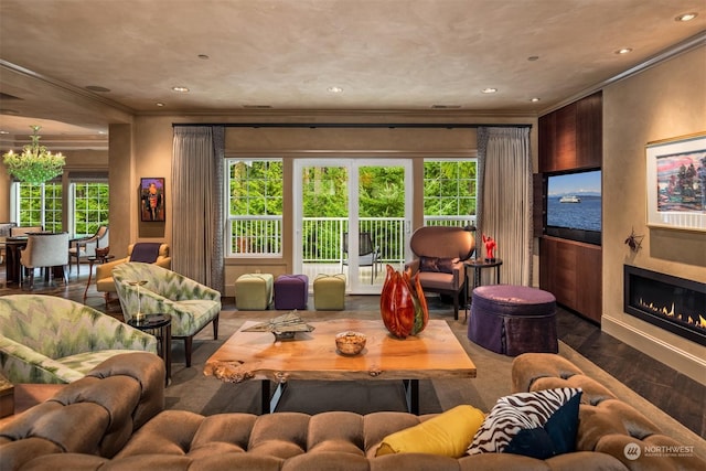 living room featuring a fireplace, ornamental molding, a wealth of natural light, and wood finished floors