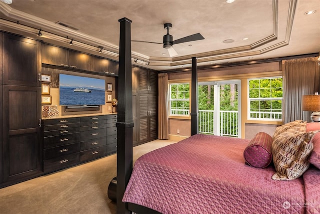 bedroom with light carpet, a tray ceiling, visible vents, and ornamental molding