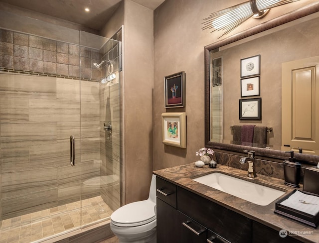 full bathroom with vanity, a shower stall, and toilet