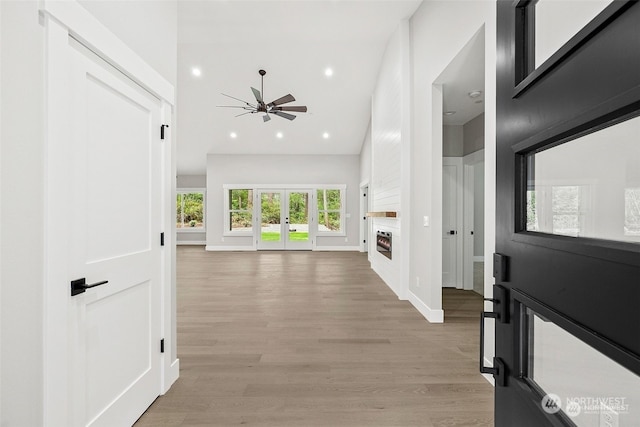 corridor with french doors and light hardwood / wood-style flooring