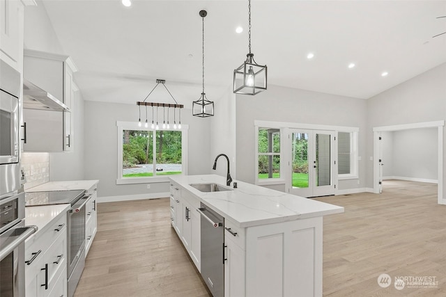 kitchen with a center island with sink, plenty of natural light, white cabinetry, and sink