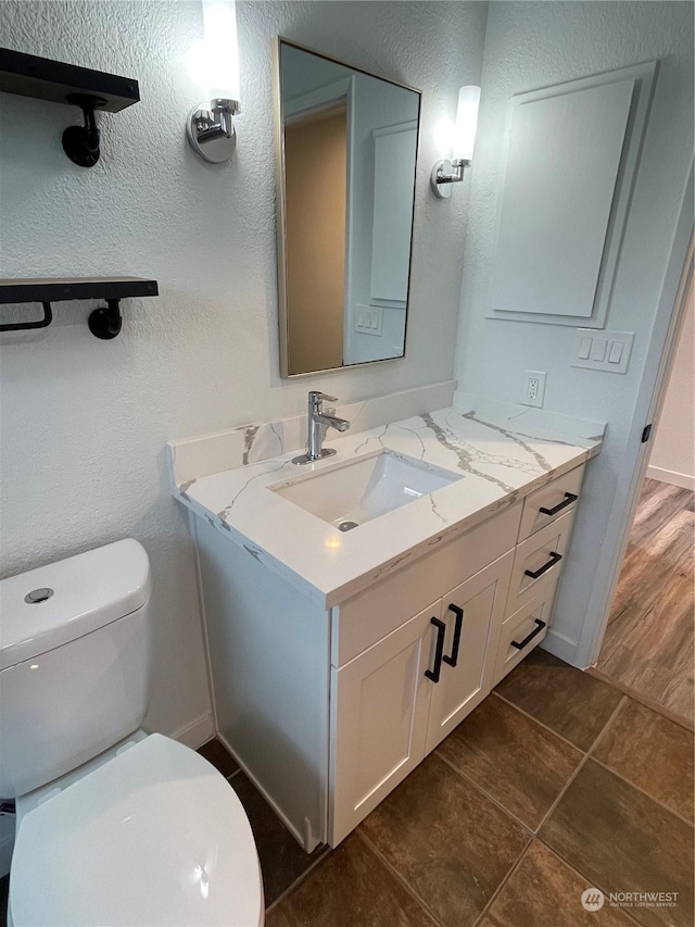 bathroom featuring tile patterned floors, vanity, and toilet