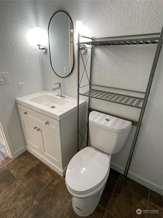 bathroom featuring tile patterned floors, vanity, and toilet