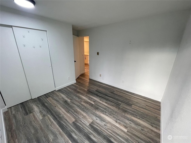 unfurnished bedroom with a closet and dark hardwood / wood-style floors