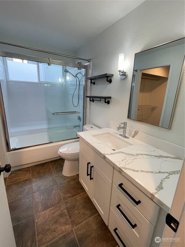 full bathroom featuring vanity, toilet, and bath / shower combo with glass door