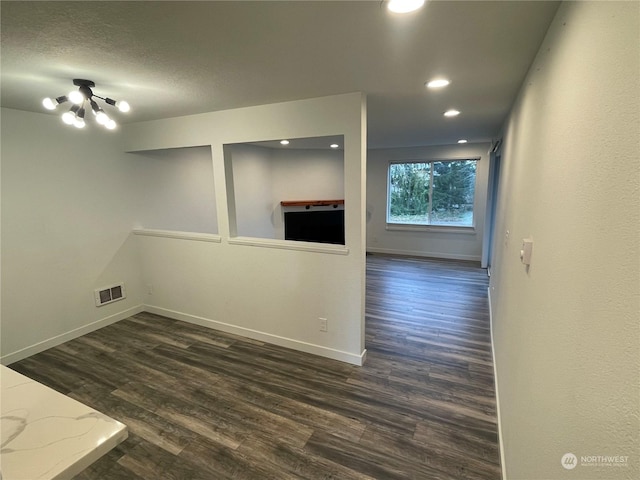 spare room with dark hardwood / wood-style flooring and a notable chandelier