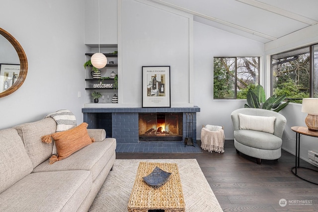 living room with vaulted ceiling with beams, dark wood-type flooring, and a brick fireplace