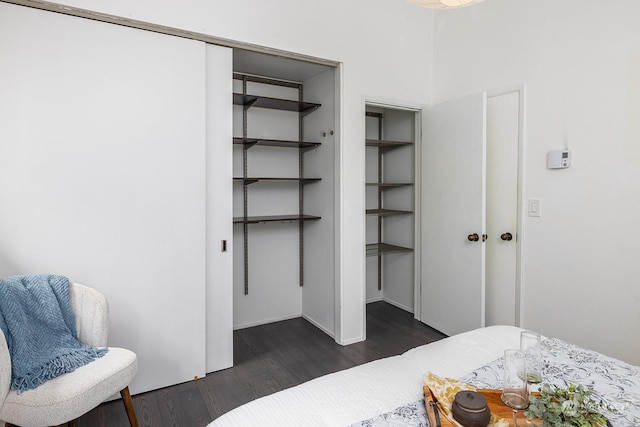 bedroom with dark hardwood / wood-style floors and a closet