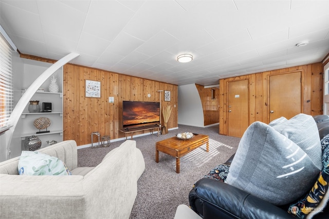 carpeted living room featuring wooden walls