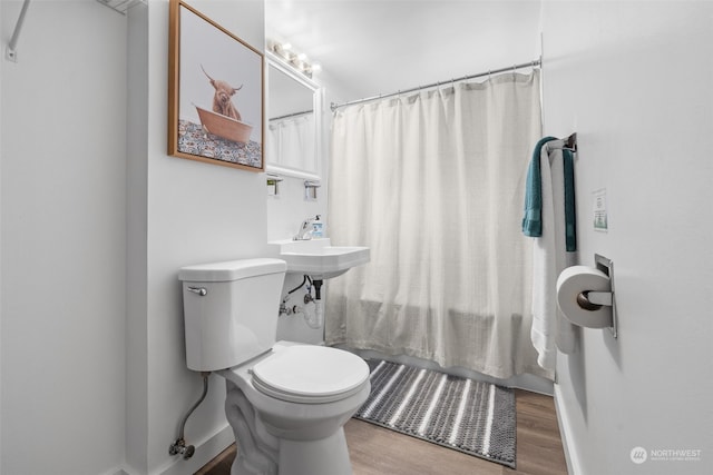 bathroom with hardwood / wood-style floors, sink, toilet, and walk in shower