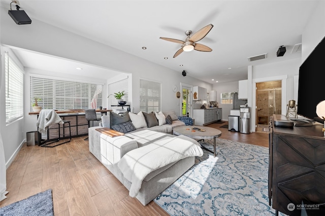 living room featuring ceiling fan and light hardwood / wood-style flooring