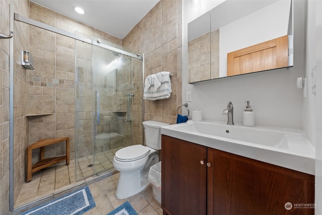 bathroom featuring vanity, walk in shower, and toilet