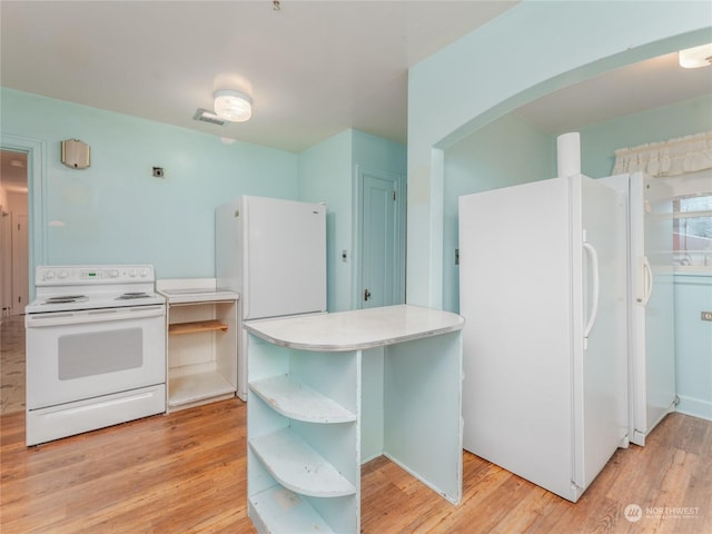 kitchen with white appliances and light hardwood / wood-style floors