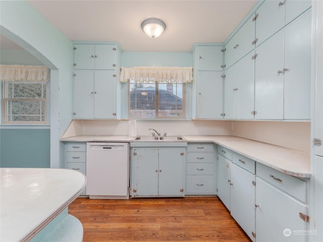 kitchen with white dishwasher, sink, and light hardwood / wood-style flooring