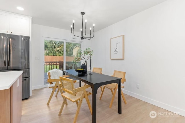 dining area with a notable chandelier and light wood-type flooring