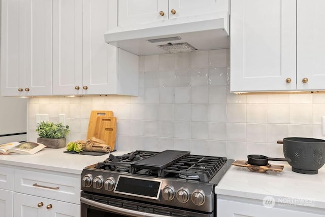 kitchen featuring gas stove, light stone counters, white cabinetry, and tasteful backsplash