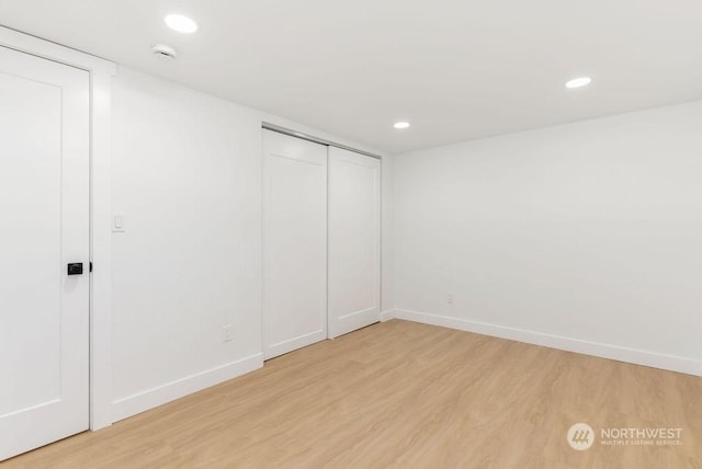 unfurnished bedroom featuring light wood-type flooring and a closet