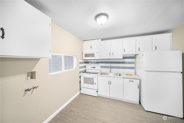 kitchen featuring white appliances, white cabinets, sink, decorative backsplash, and light wood-type flooring