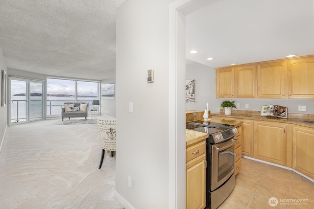 kitchen with electric range, light brown cabinets, a textured ceiling, open floor plan, and recessed lighting