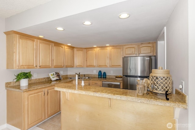 kitchen with light brown cabinets, recessed lighting, appliances with stainless steel finishes, and a sink