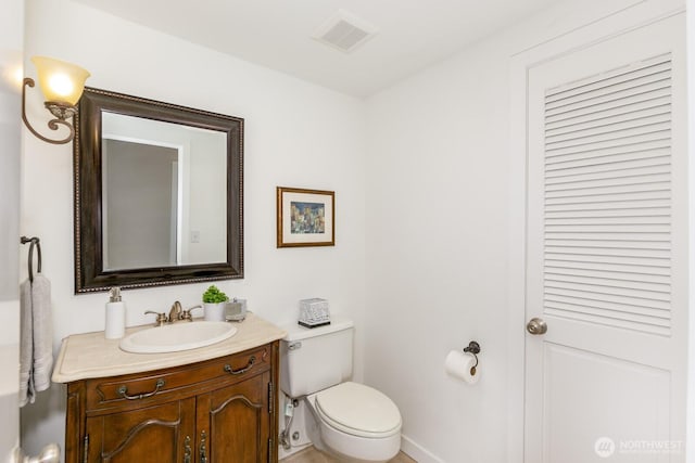 bathroom featuring visible vents, toilet, vanity, and baseboards