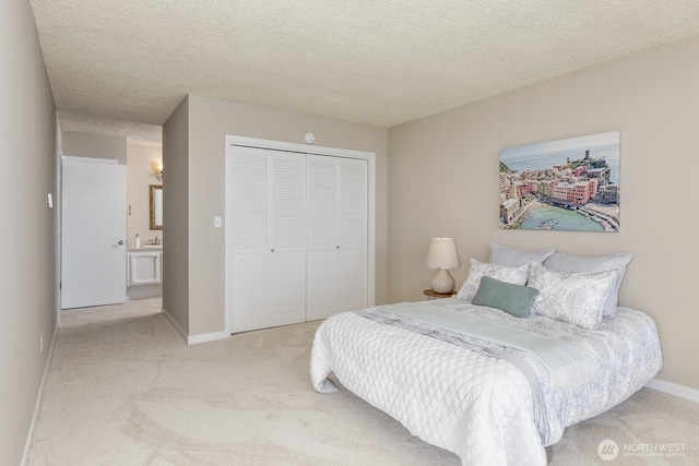 carpeted bedroom with a closet, baseboards, and a textured ceiling