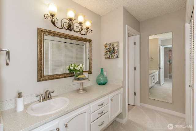 bathroom with vanity, baseboards, and a textured ceiling