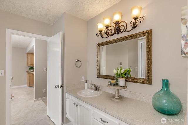 bathroom featuring a textured ceiling, vanity, and baseboards