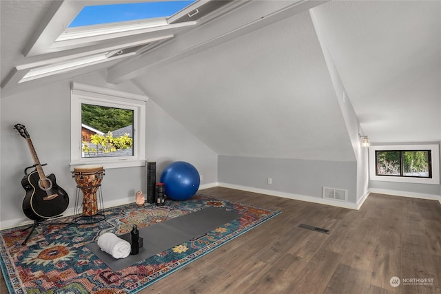 exercise area with dark wood-type flooring and lofted ceiling