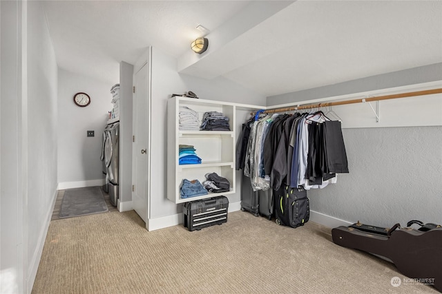 walk in closet featuring separate washer and dryer and light colored carpet