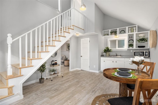 interior space featuring wood-type flooring, high vaulted ceiling, and sink