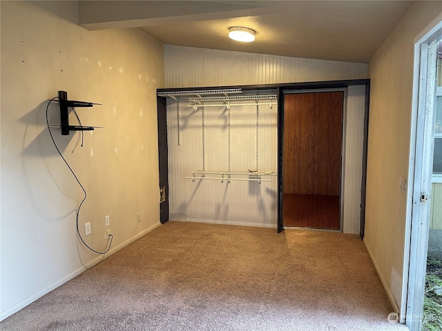 unfurnished bedroom featuring lofted ceiling, carpet floors, and a closet