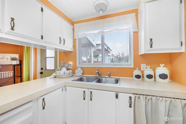 kitchen featuring white cabinetry and sink