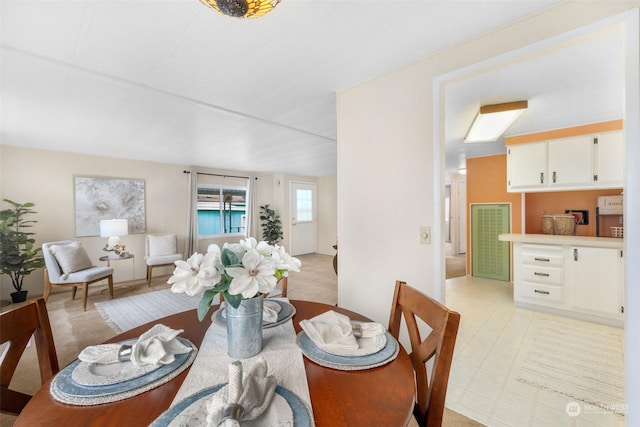 dining space featuring light carpet