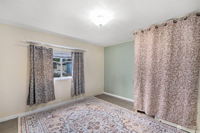 tiled spare room with a textured ceiling