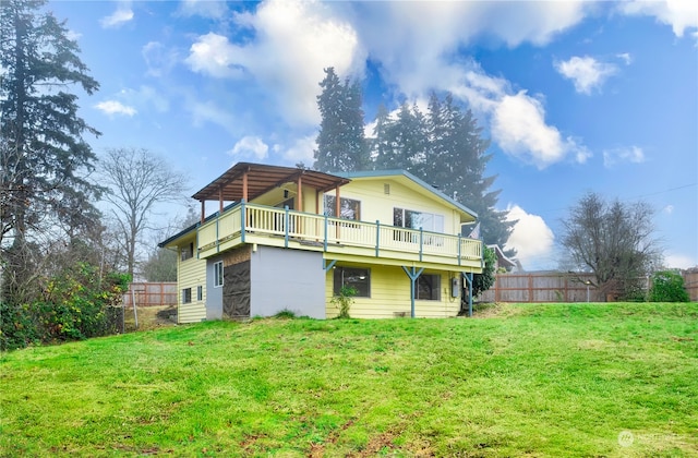 rear view of property featuring a yard and a deck