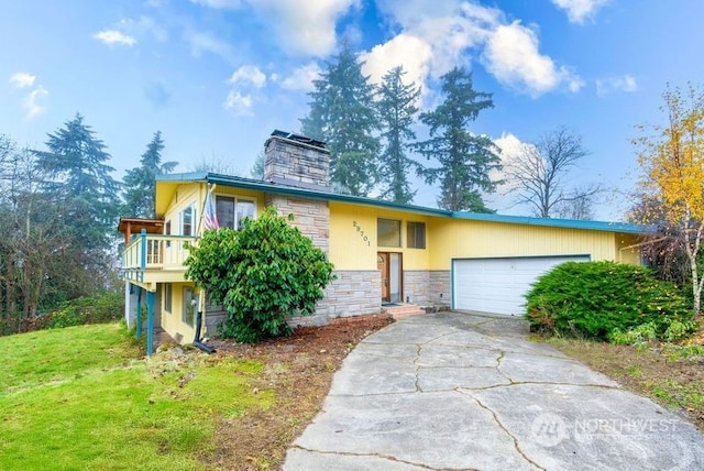 view of front of property featuring a wooden deck, a front yard, and a garage