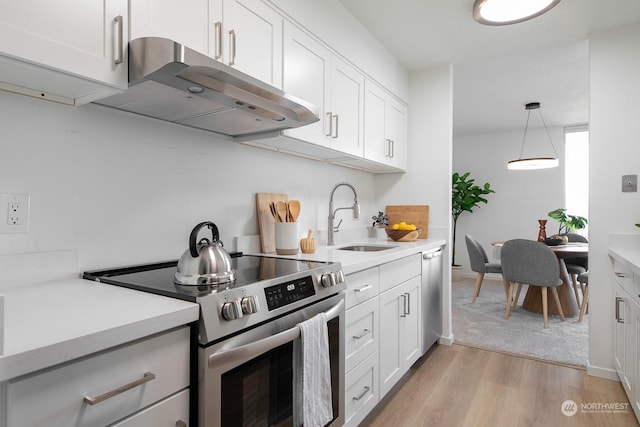 kitchen featuring white cabinets, appliances with stainless steel finishes, light hardwood / wood-style floors, and sink