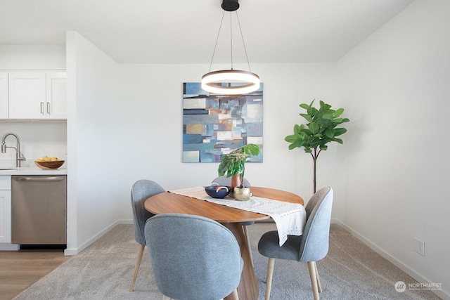 dining room with sink and light wood-type flooring