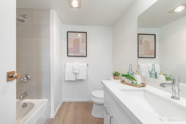 full bathroom featuring vanity, toilet, wood-type flooring, and tiled shower / bath