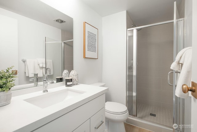 bathroom featuring toilet, vanity, an enclosed shower, and hardwood / wood-style flooring