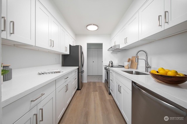 kitchen featuring white cabinetry, sink, appliances with stainless steel finishes, and light hardwood / wood-style flooring