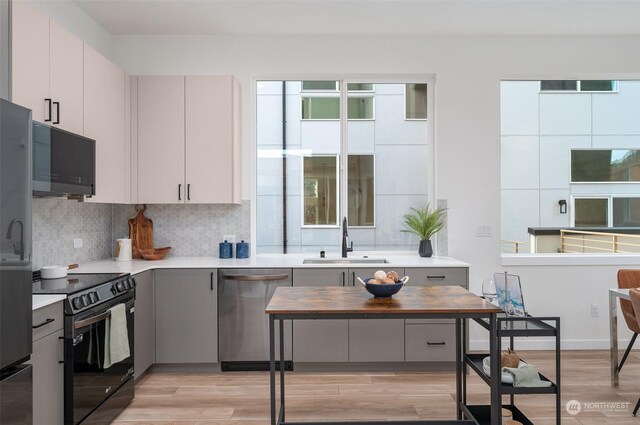 730C Broadway E, Seattle, WA 98102 - kitchen featuring black appliances, light countertops, decorative backsplash, and light wood-style floors