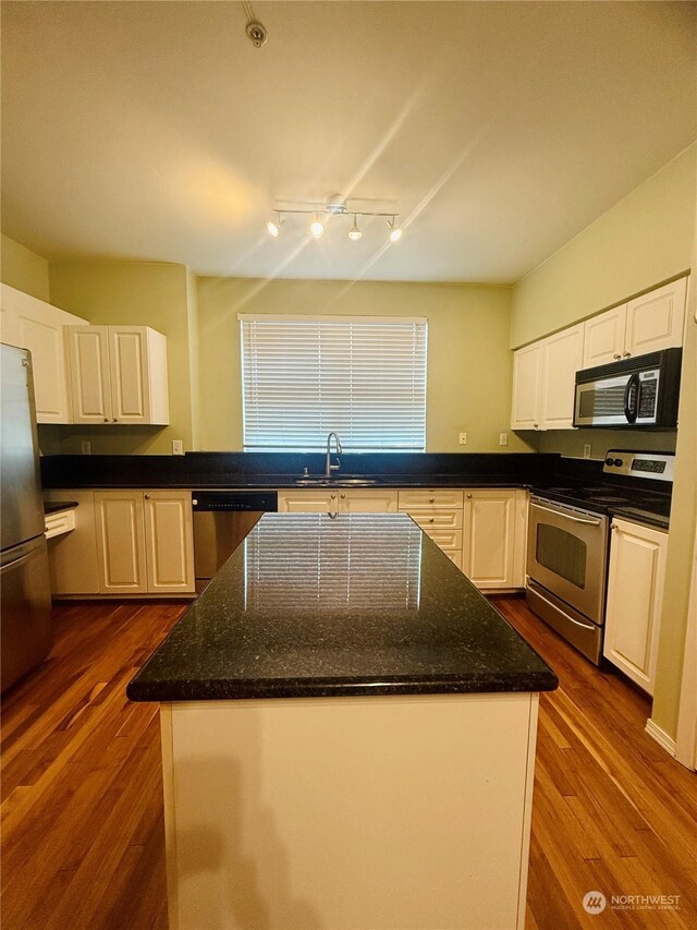 kitchen with white cabinets, dark hardwood / wood-style flooring, sink, and appliances with stainless steel finishes