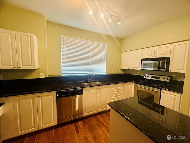 kitchen with sink, white cabinets, stainless steel appliances, and dark hardwood / wood-style floors