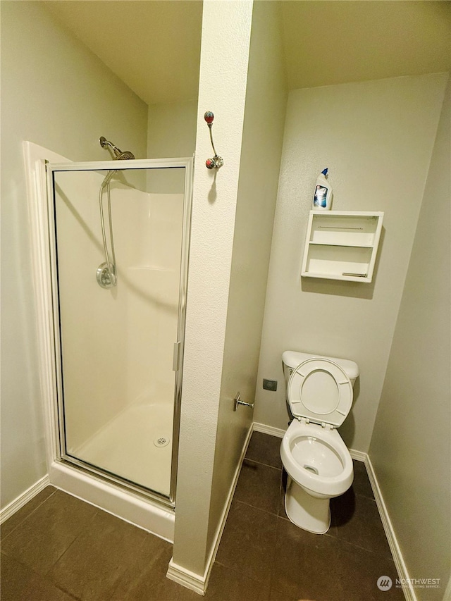 bathroom with toilet, tile patterned floors, and a shower with shower door