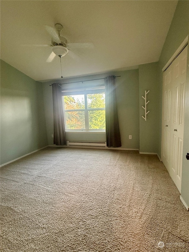 carpeted empty room with lofted ceiling, ceiling fan, and a baseboard heating unit