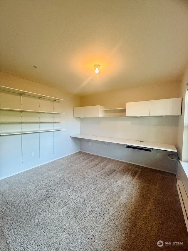 basement with carpet flooring and baseboard heating