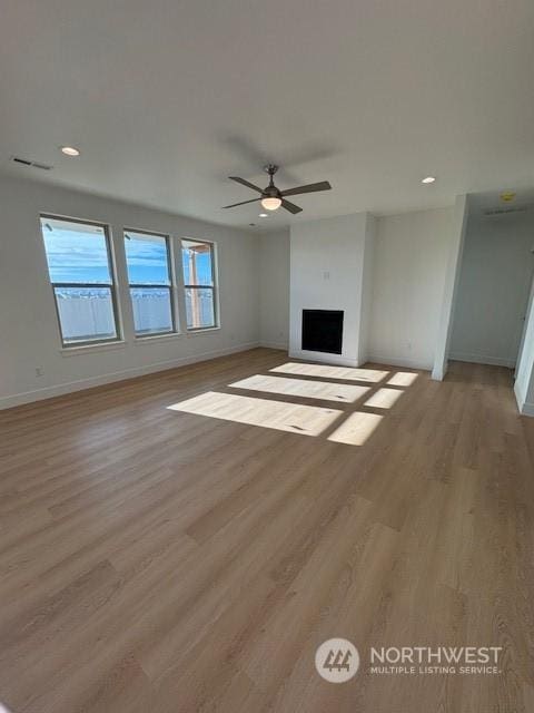 unfurnished living room featuring ceiling fan and light hardwood / wood-style flooring