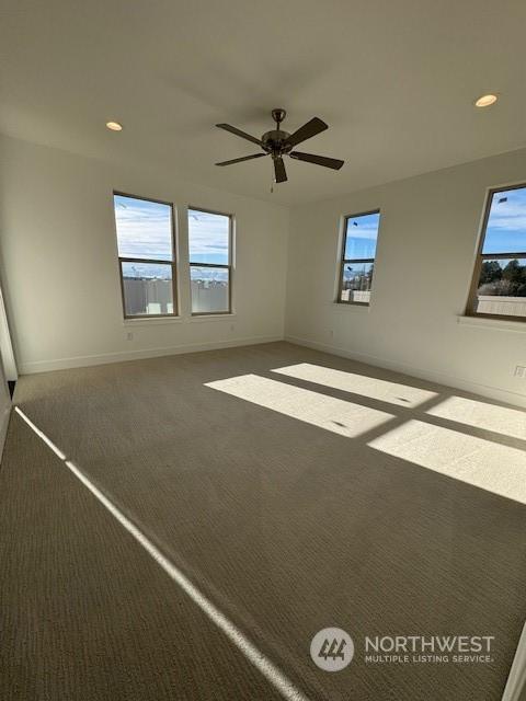 carpeted spare room with ceiling fan